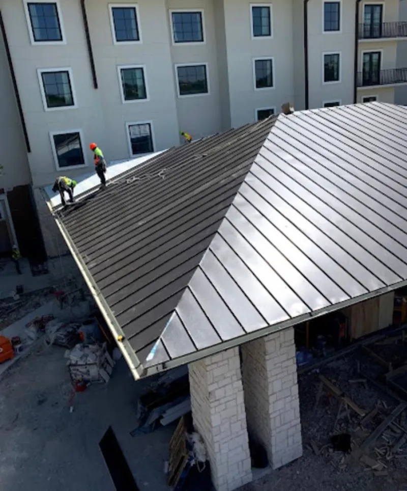 Crew installing standing seam metal roof panels on a commercial project in Diamond Springs